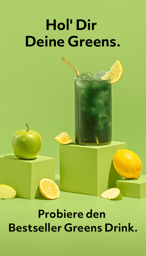Super Greens Extreme im Glas umgeben von Zitronen und Äpfeln