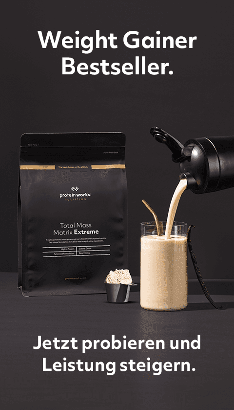 Ein Shake wird in ein Glas gegossen vor schwarzem Hintergrund