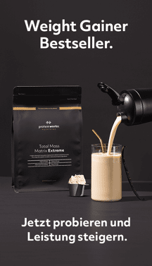 Ein Shake wird in ein Glas gegossen vor schwarzem Hintergrund
