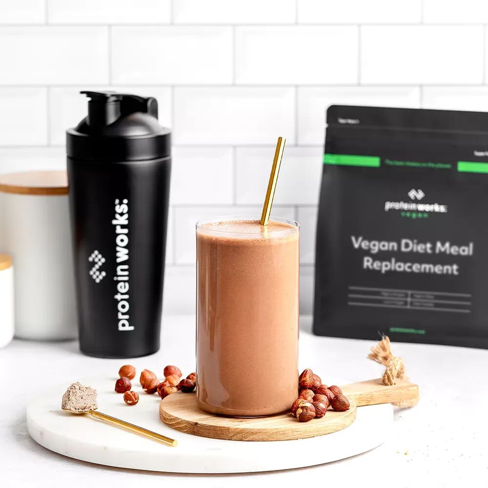 Glass of Vegan Diet Meal Replacement with a pouch and shaker