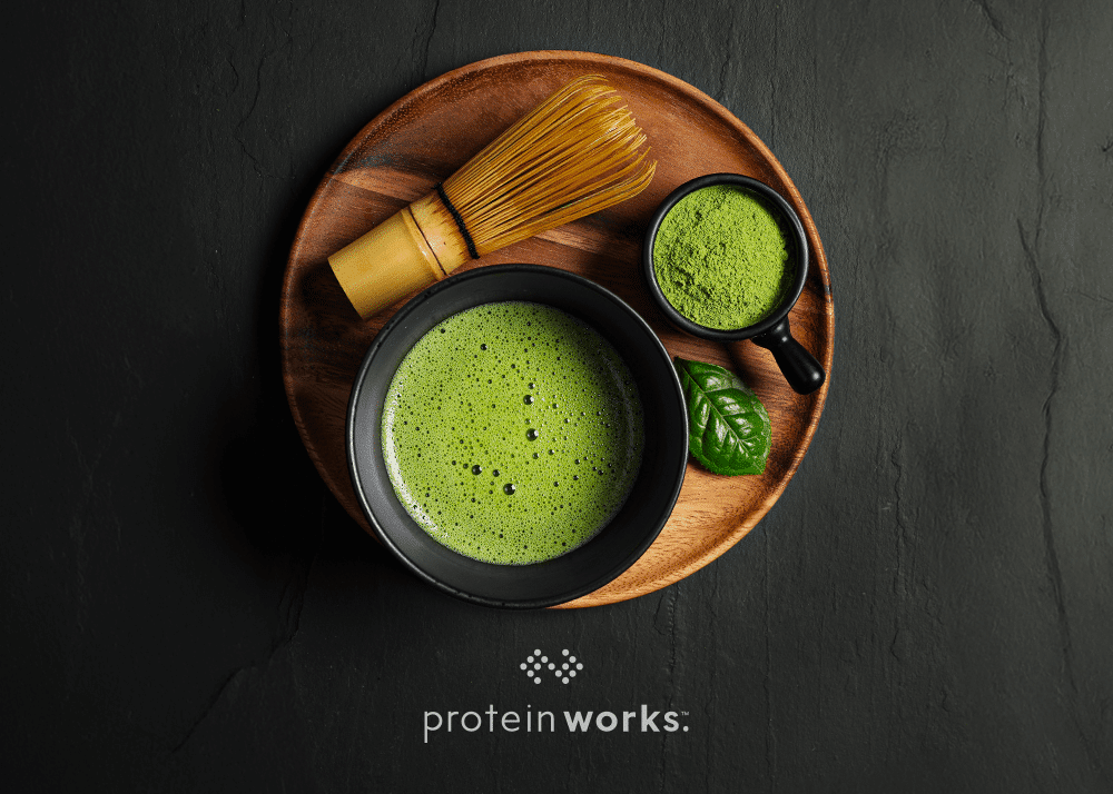 Matcha Green Tea on a wooden board with matcha powder on the side