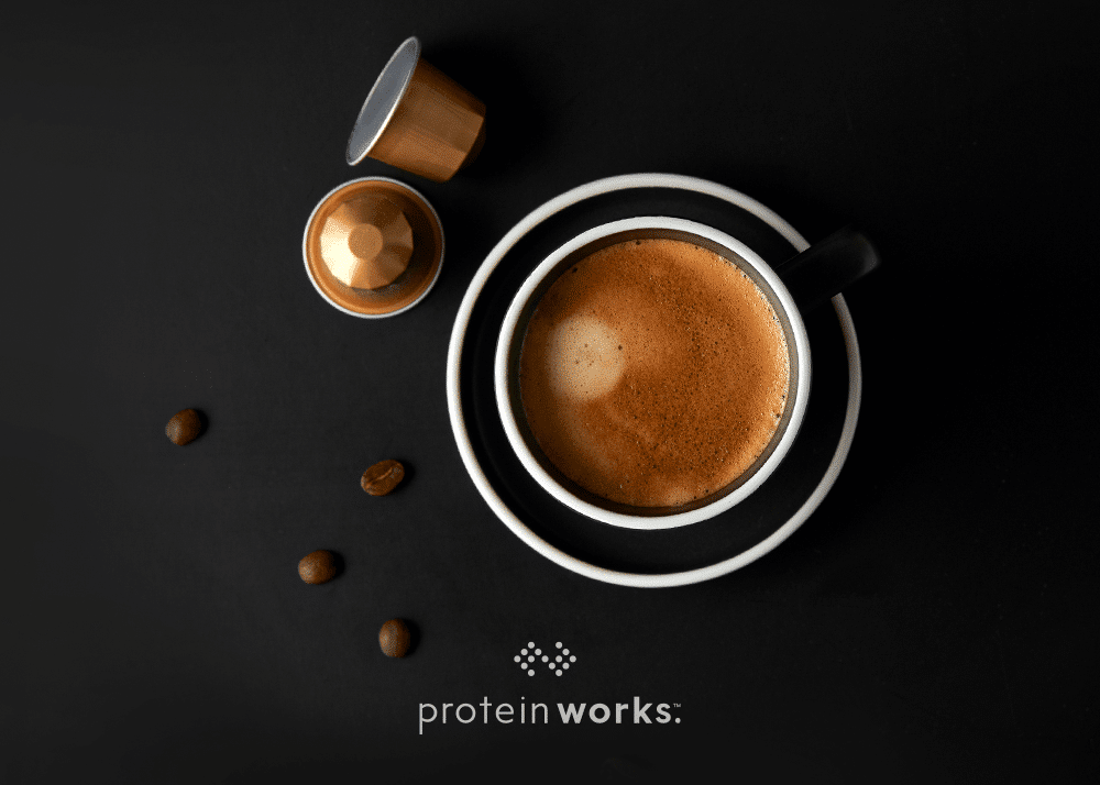 Cup of black coffee on a dark background with coffee beans as decoration to showcase caffiene