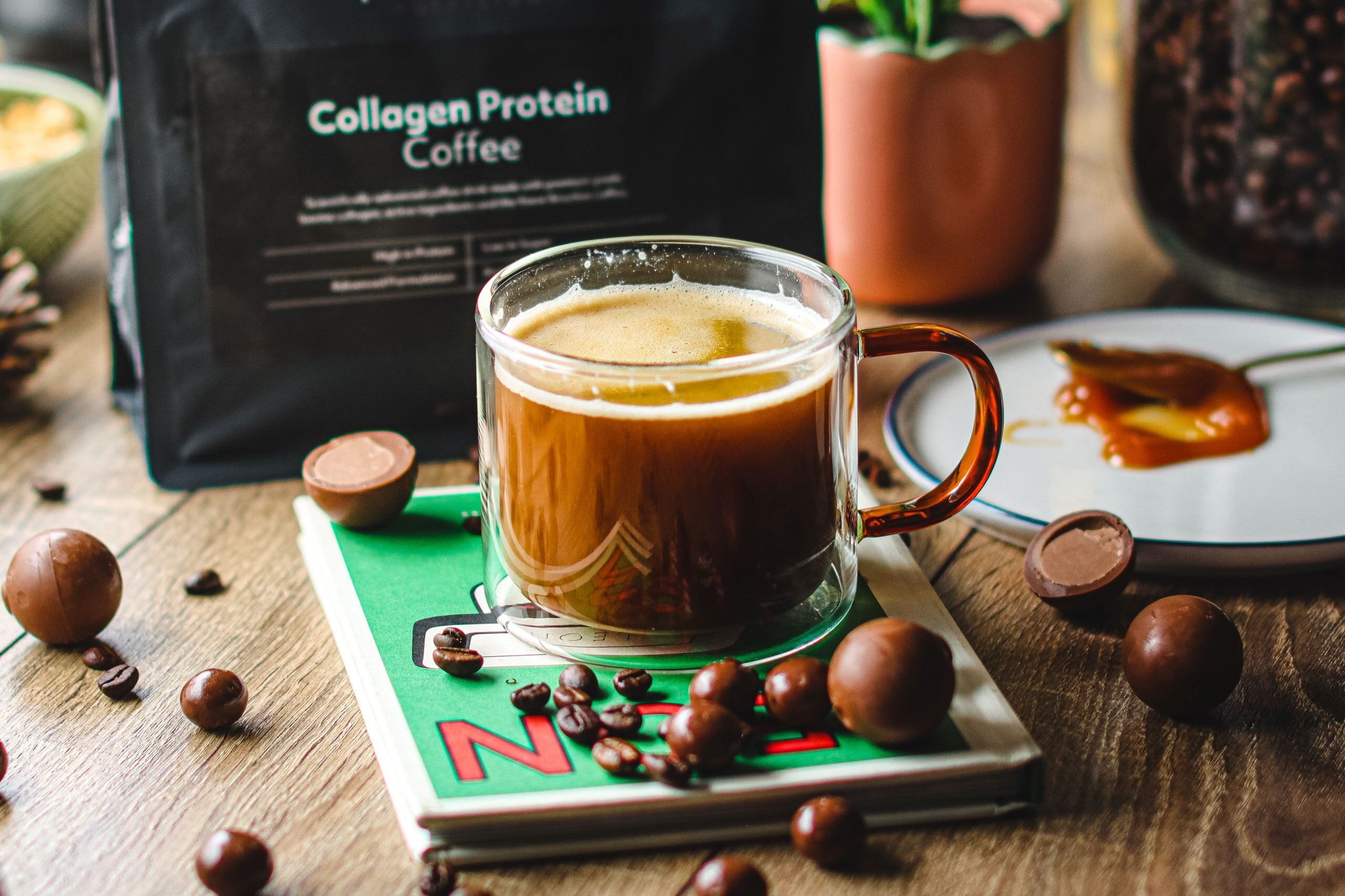 Clear cup of a Collagen Protein Coffee, with a black protein works pouch in the background