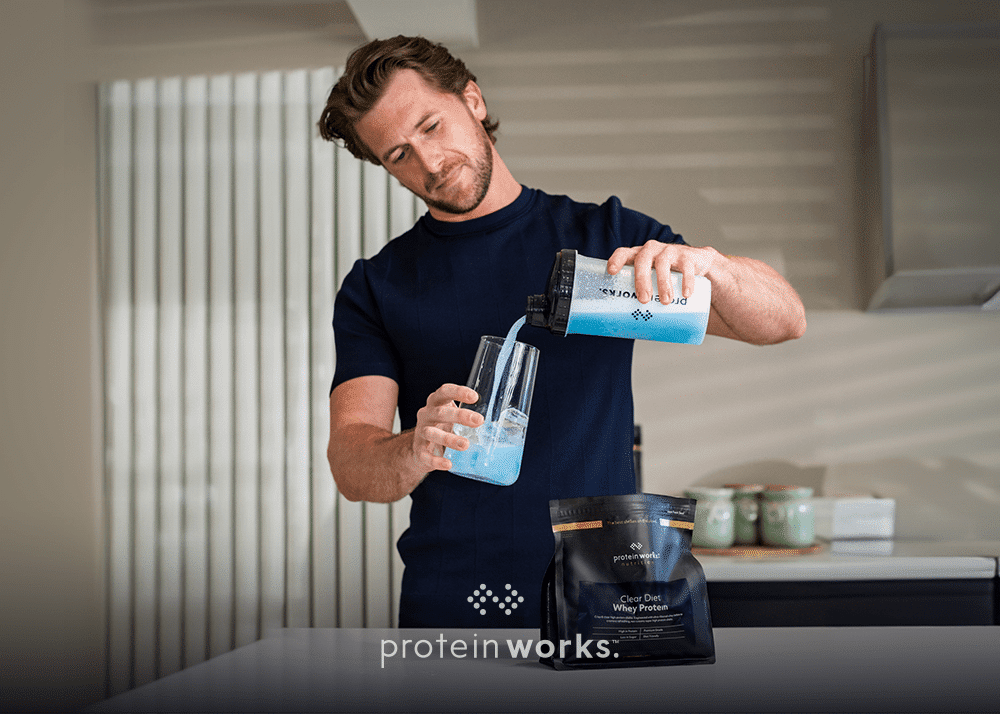 A man making a clear diet whey protein shake