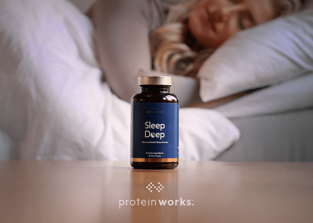 A woman sleeping behind a tub of Sleep Deep